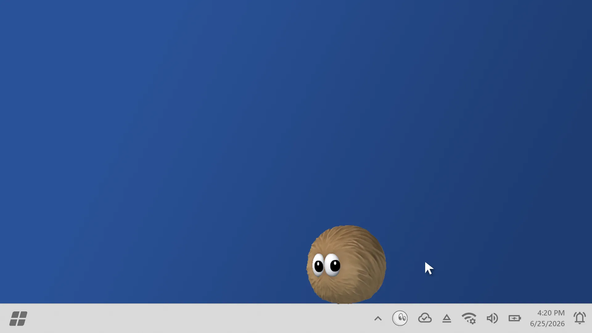 Fuzzy Buddy, a brown furry ball with googly eyes, sitting on the desktop